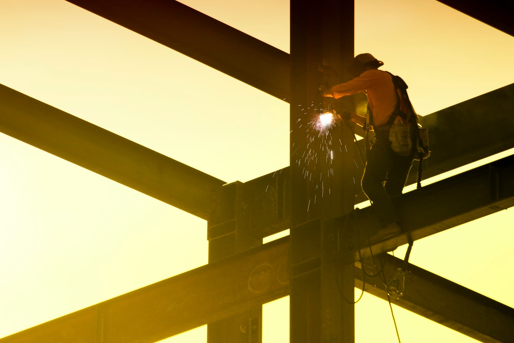 Steel worker welding a beam at height